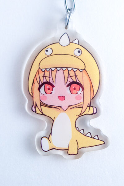 Close up of acrylic Keychain featuring Nijika in a dino onsie from Bocchi the Rock!